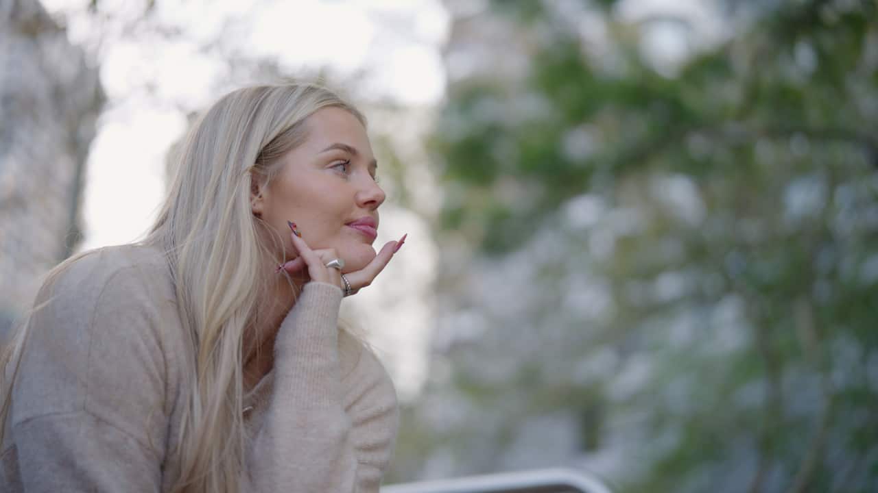 A young woman with blonde hair in a beige jumper