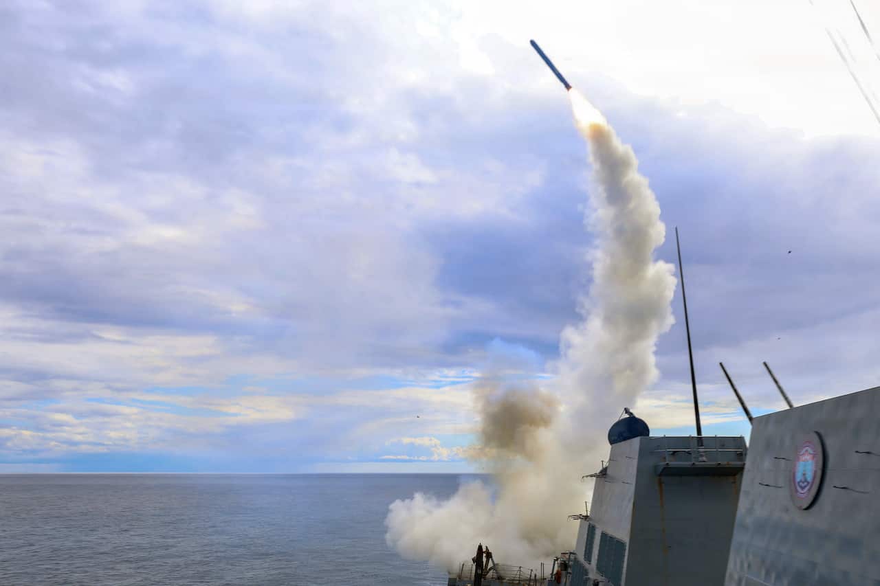 A rocket being fired from a naval warship at sea