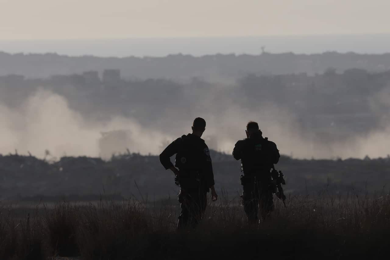 The back of two soldiers in shadow.