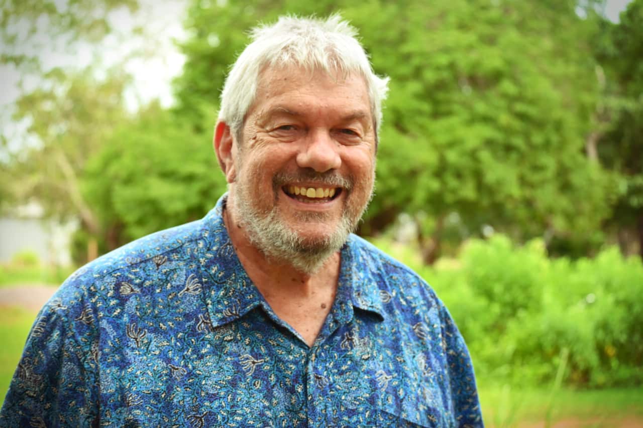 A man wearing a blue shirt and smiling