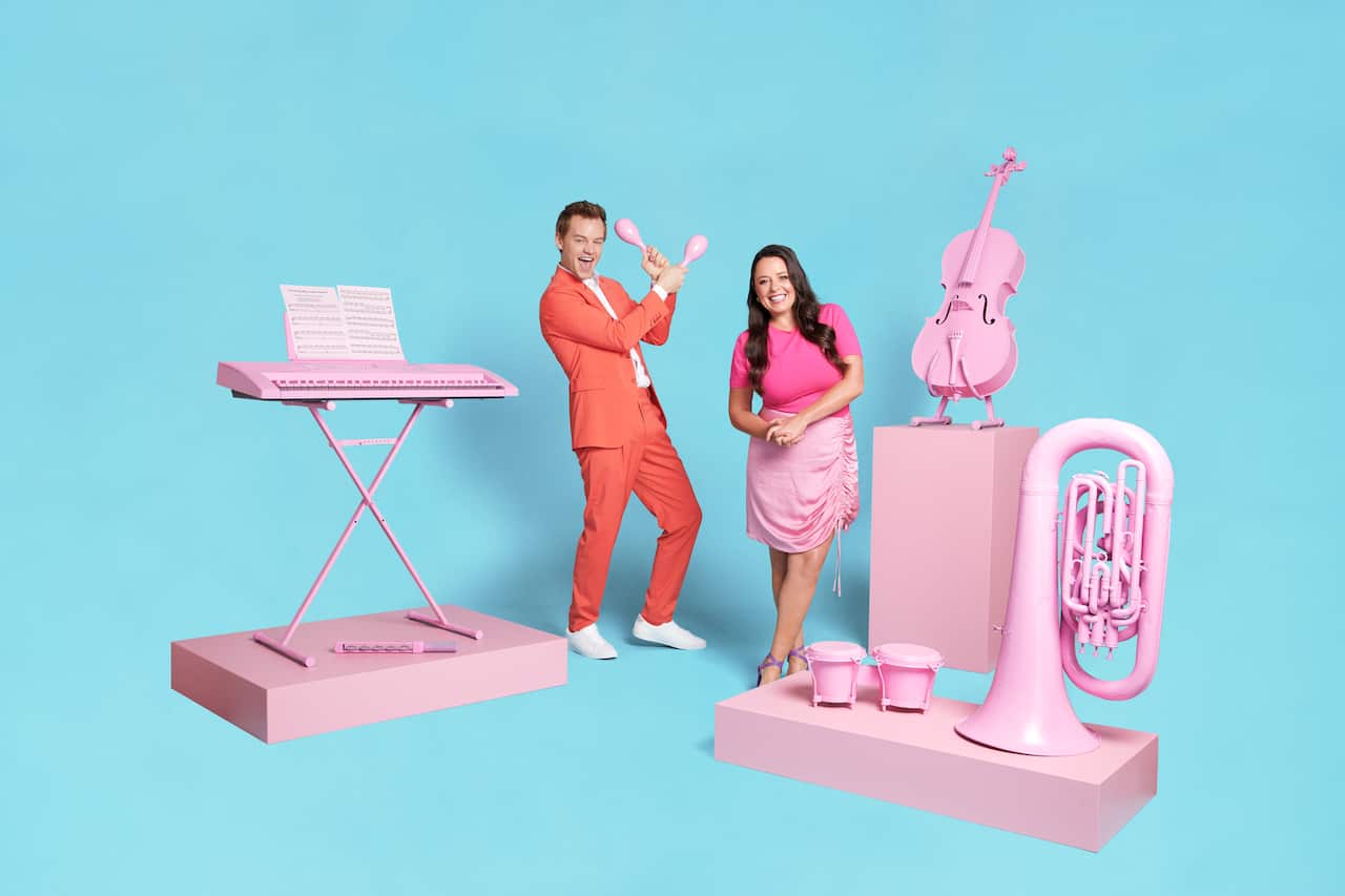 Myf Warhurst & Joel Creasey stand among pastel pink instruments