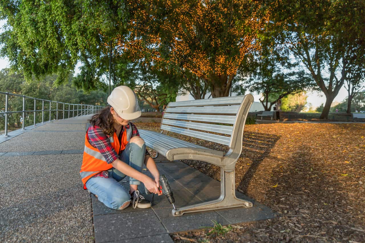 Young girl fixing park benches