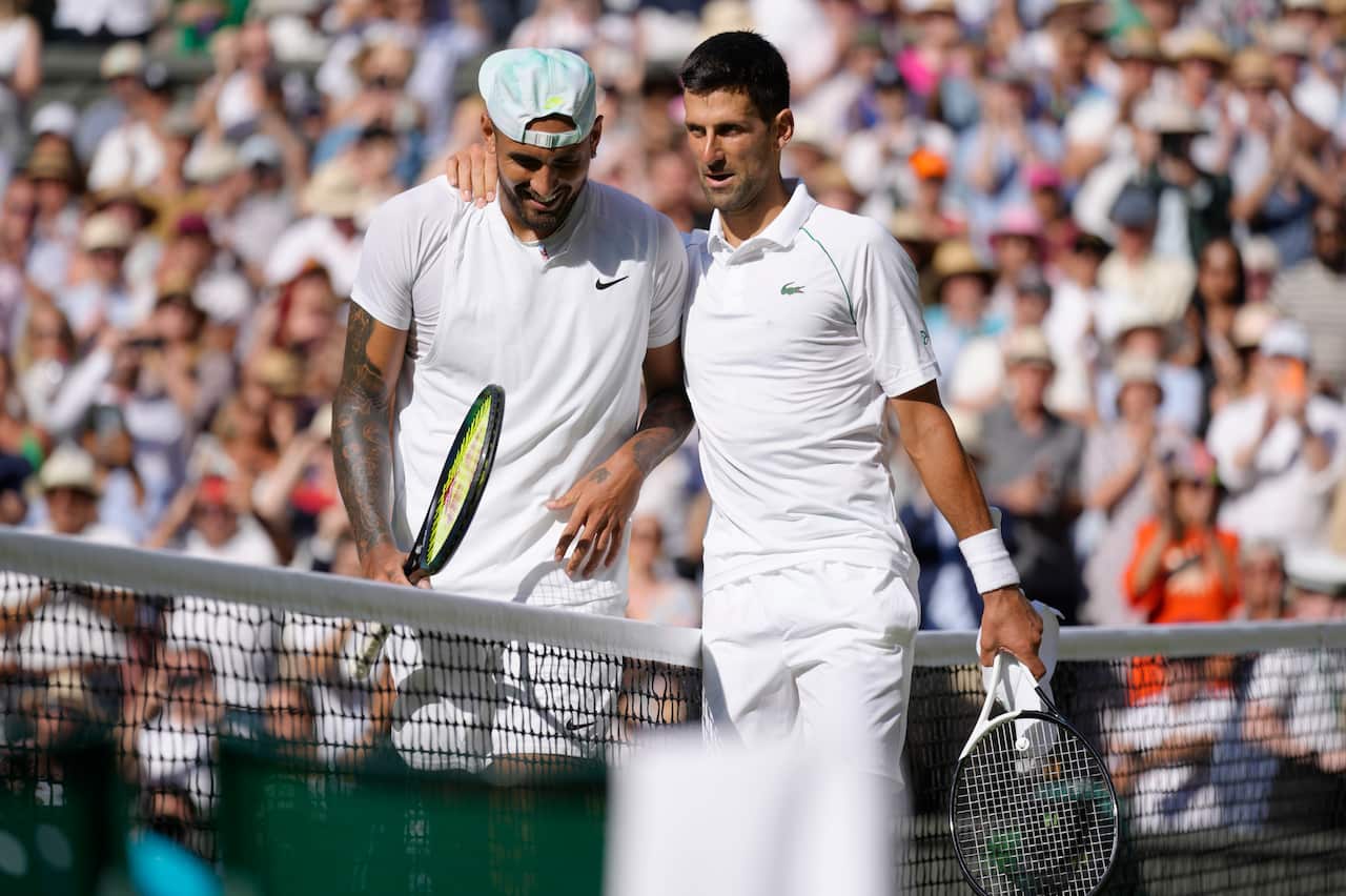 A man with his arm on another's shoulder as they stand on either side of a tennis net.