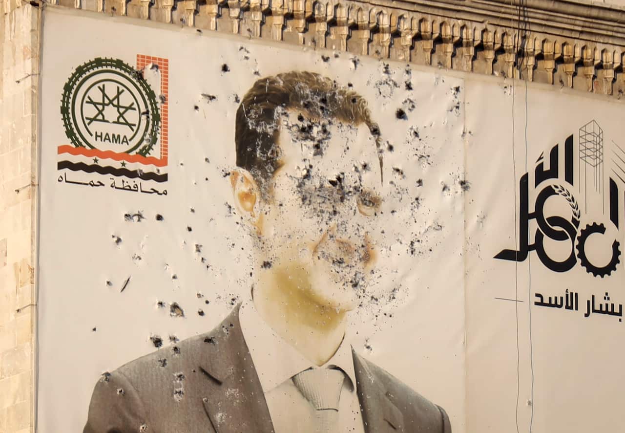 An image of Syrian President Bashar Assad, riddled with bullets, on the facade of a provincial government office
