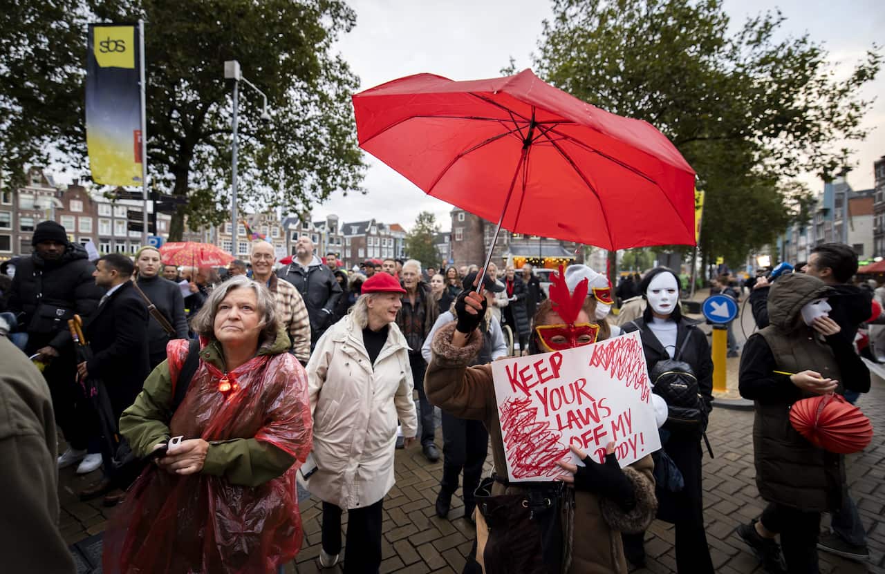 Protesters standing outside holding placards.