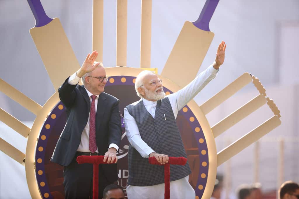 Two men riding on a chariot.