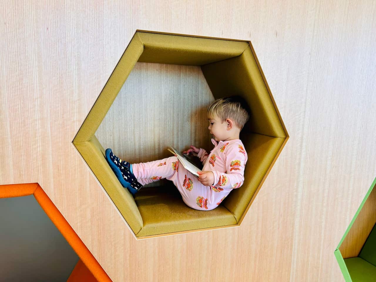 Niño mirando un libro en la biblioteca de St Kilda