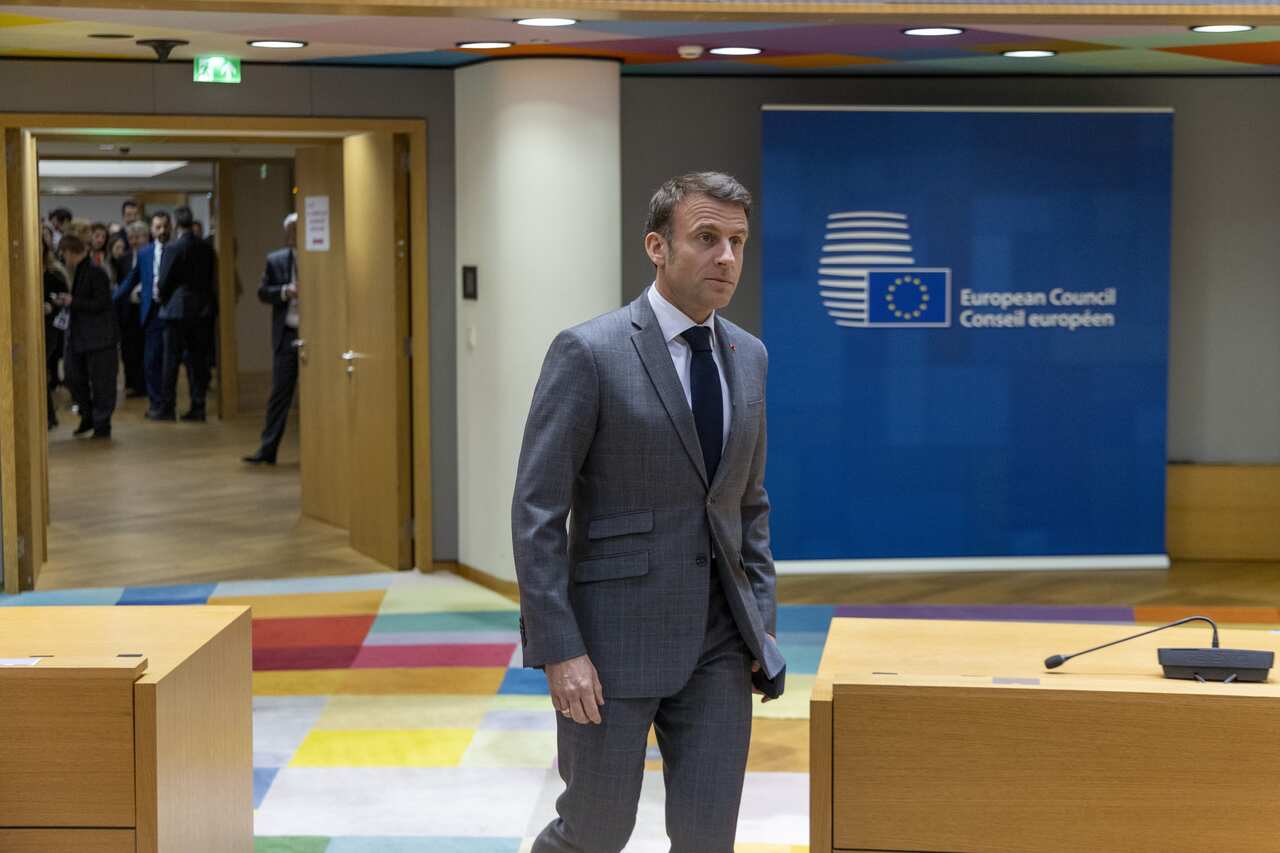 Emmanuel Macron in a suit inside