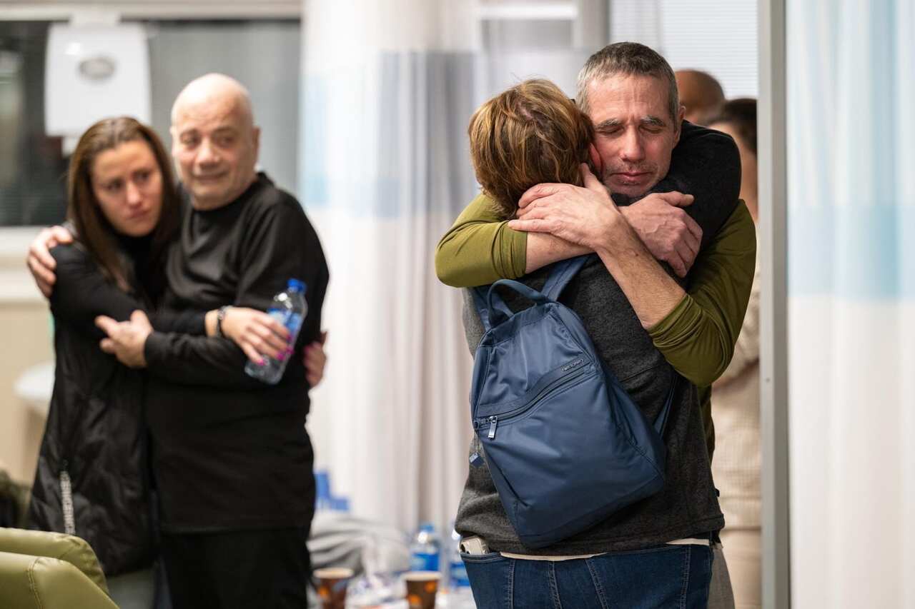 A released hostage hugs someone in an airport