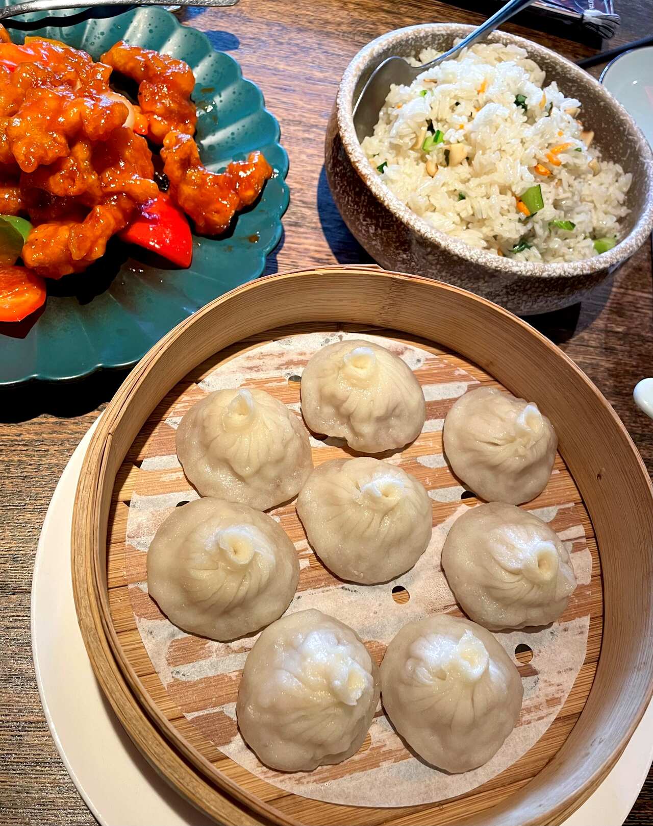Dumplings, sweet and sour pork and friend rice on a table at a restaurant.