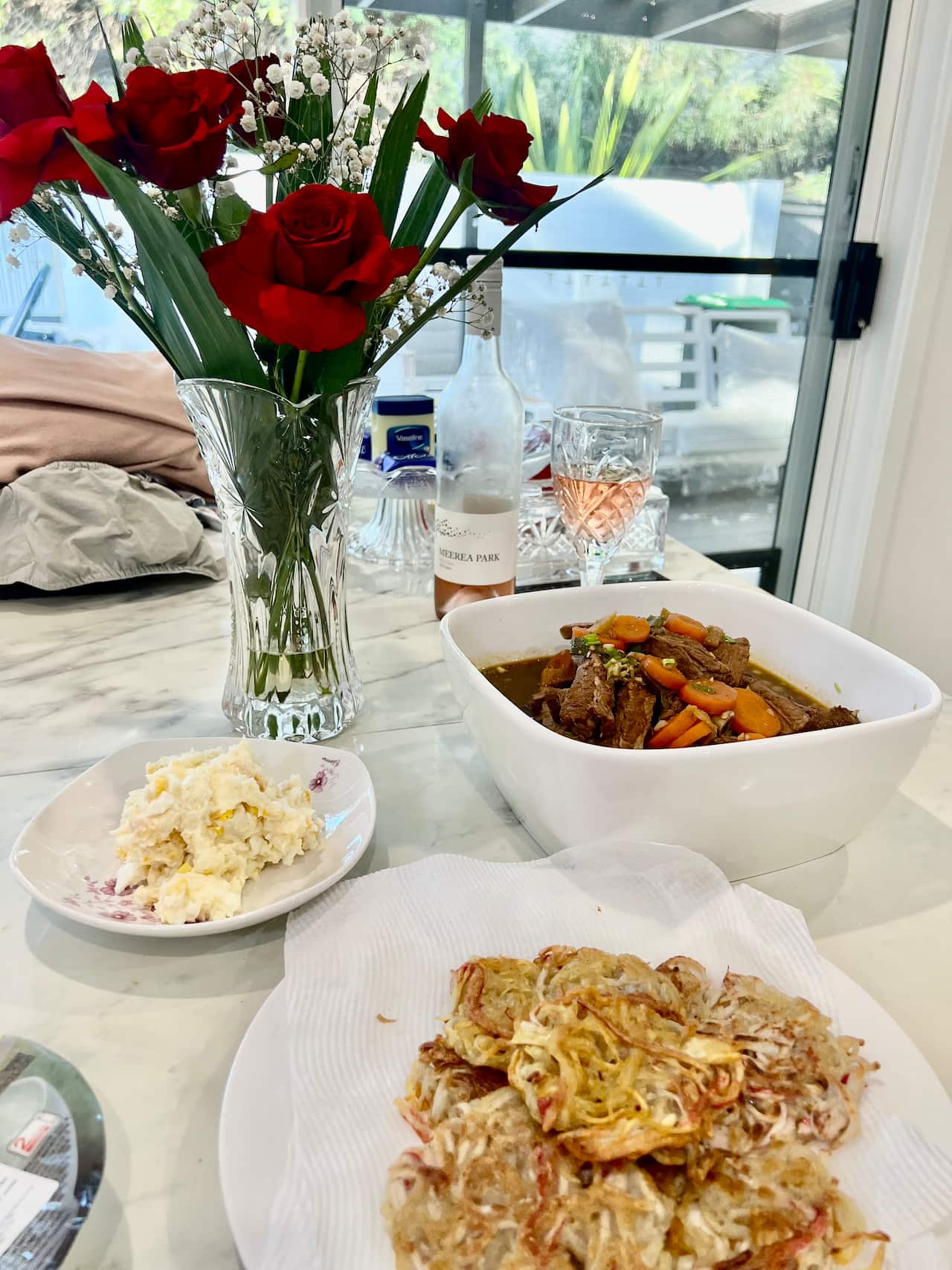 Chinese food in plates and bowls on a marble table.