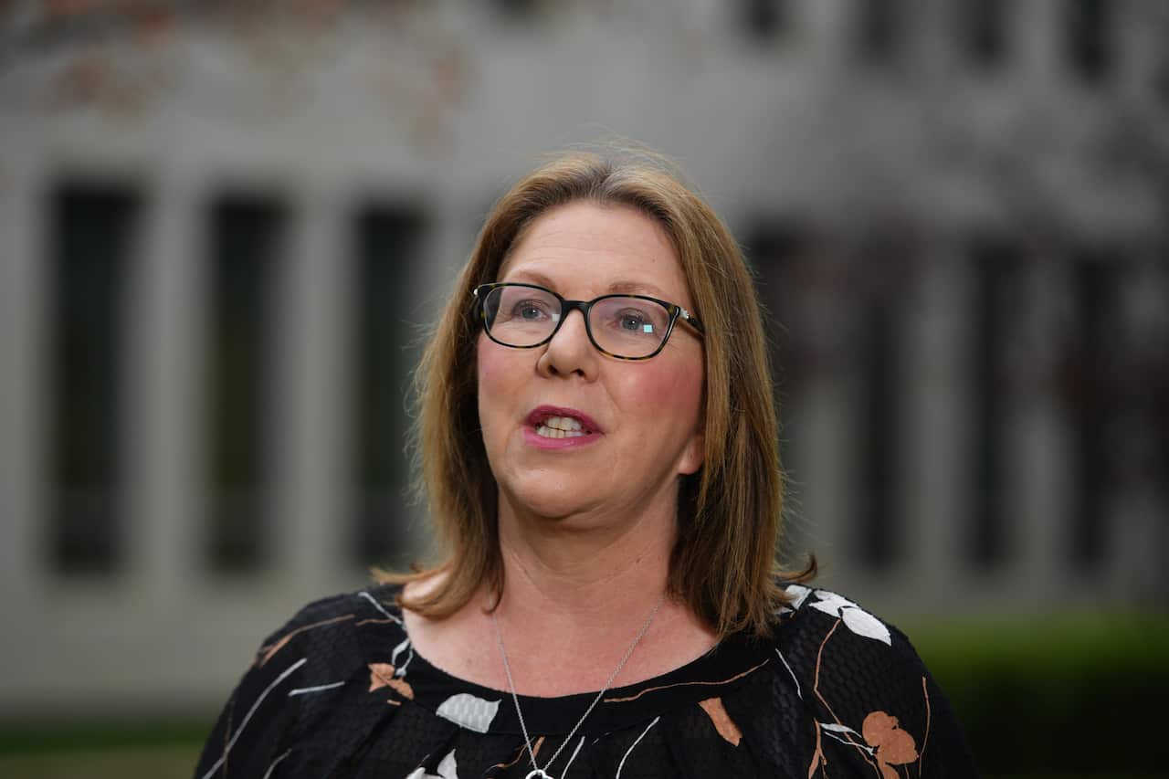 A woman standing outside speaking.