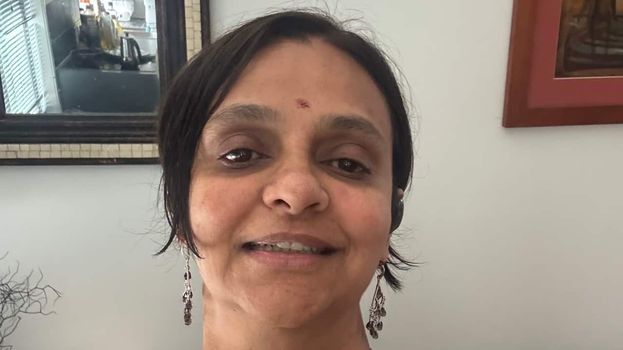 a closeup of a woman with brown hair and wearing a bindi