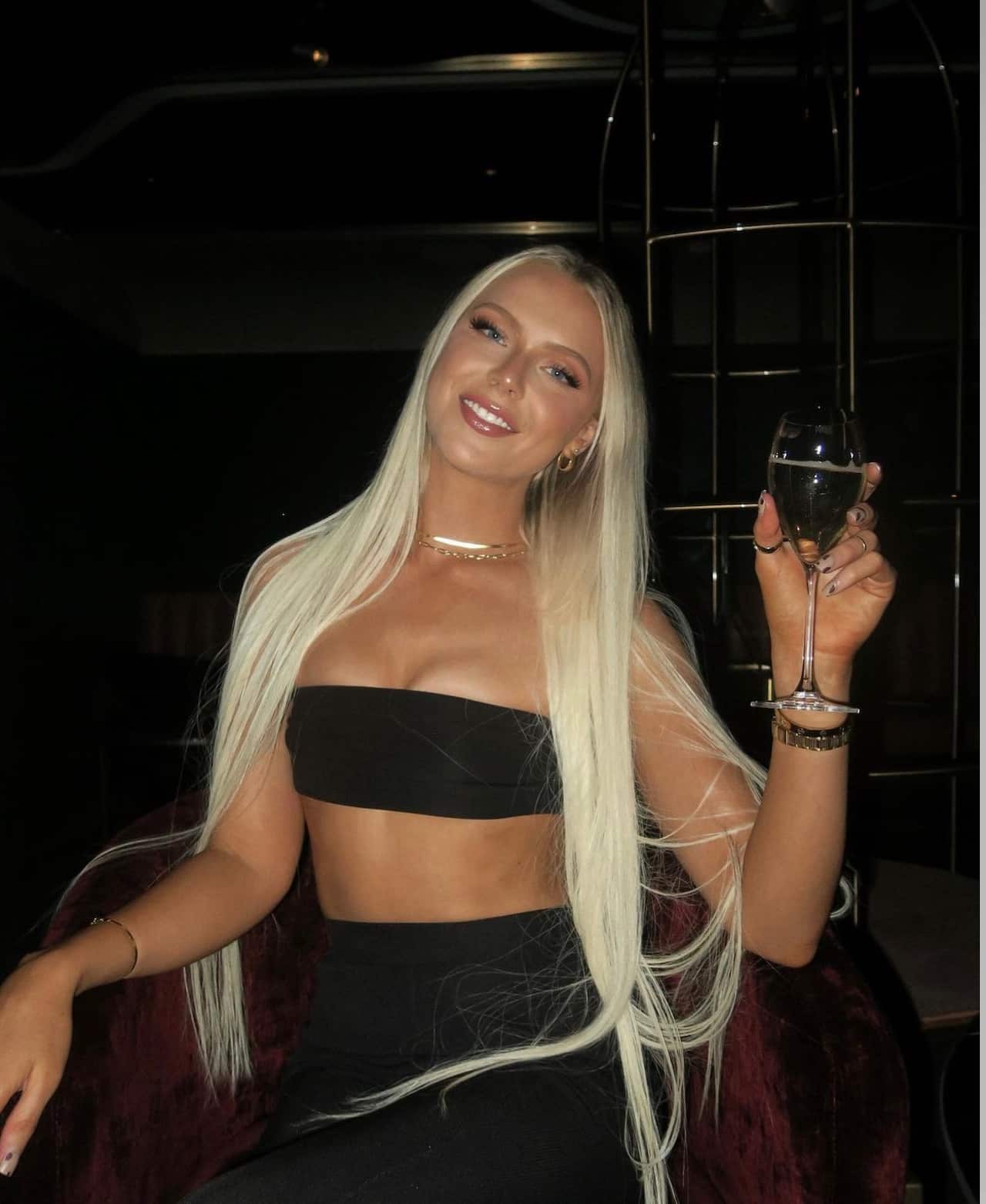 A young woman on a chair holding a glass of champagne
