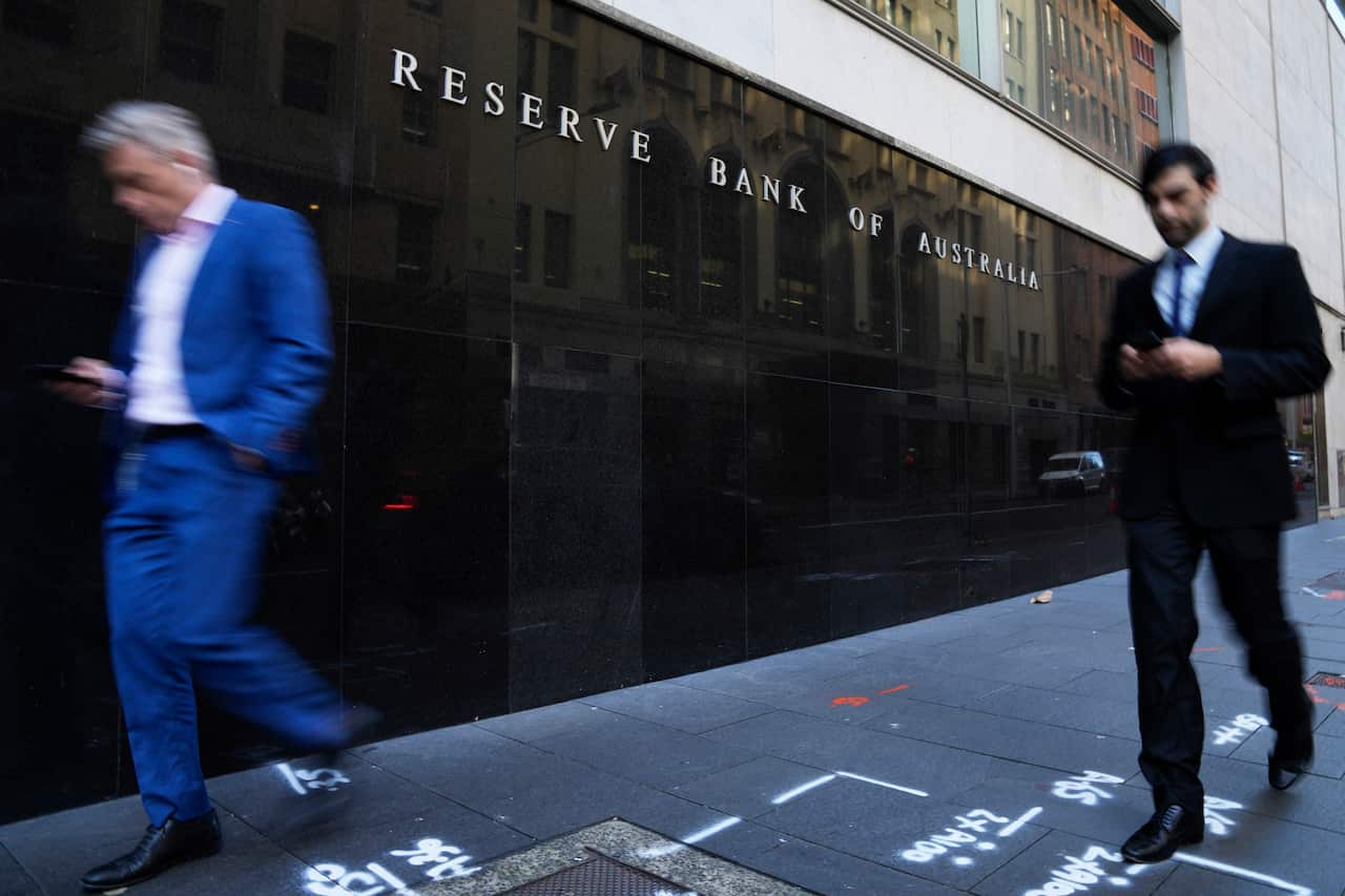 People walking past a building with a sign that reads: "Reserve Bank of Australia".