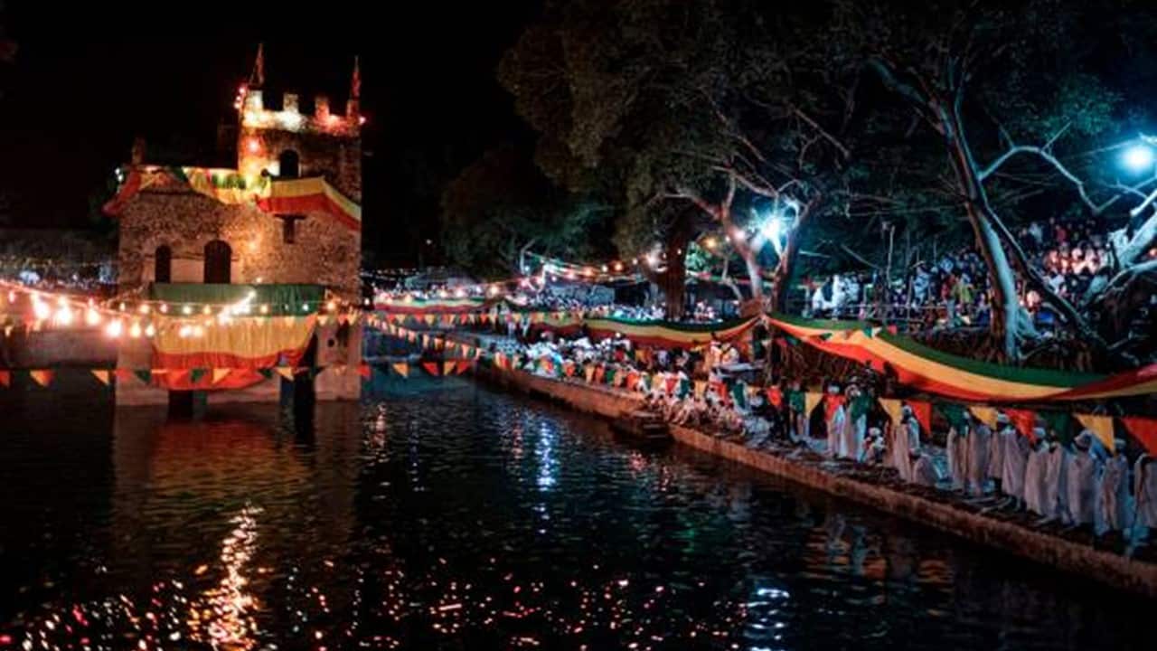 Ethiopian Orthodox Christian priests stand next to a pool during the celebration of Timkat.jpg