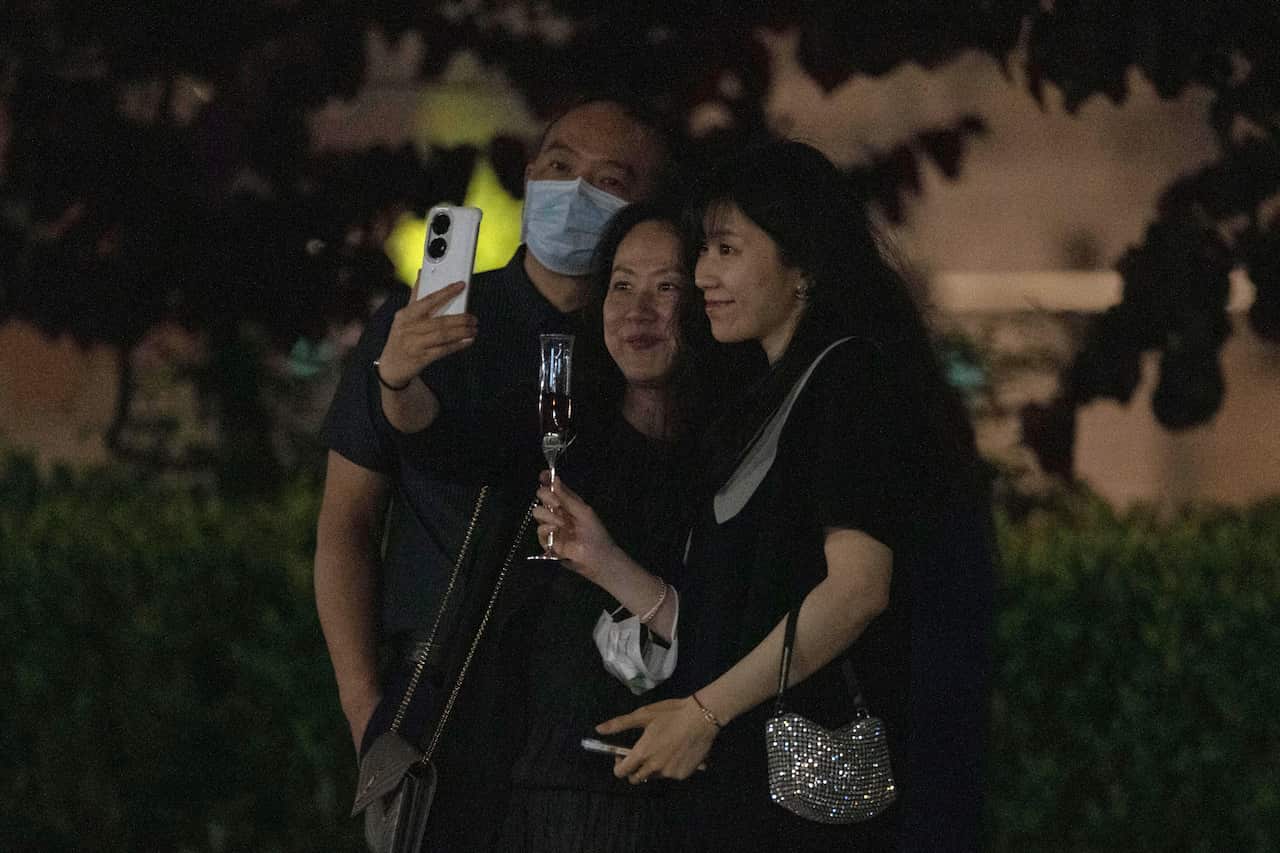 Shanghai residents celebrate with a toast as they pose for a selfie