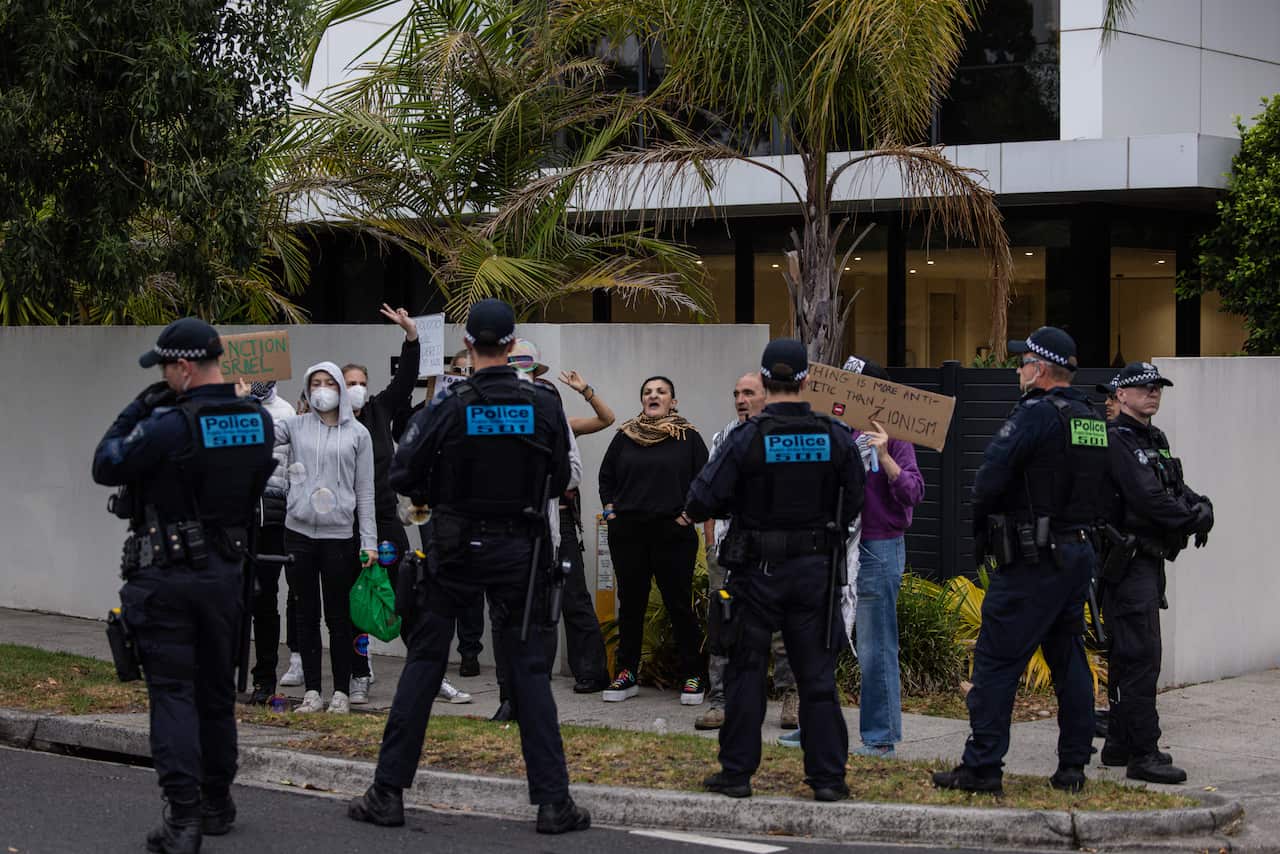 Protesters are being watched by police.