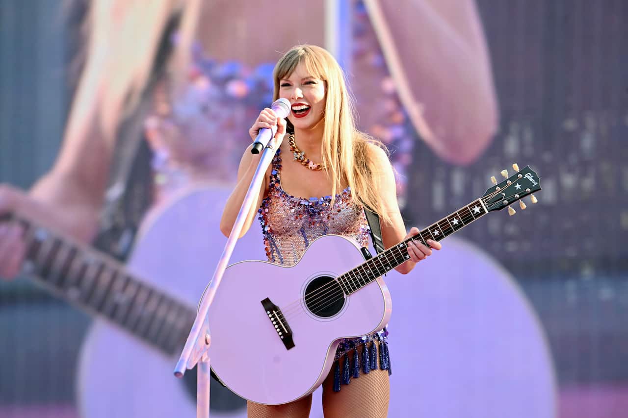 Taylor Swift on stage with a guitar.