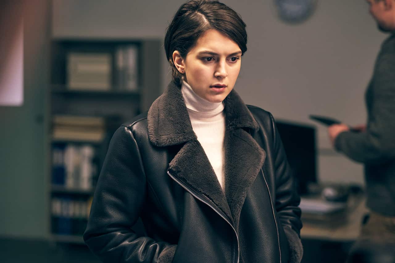 Swedish actor Mimosa Willamo plays a detective. She looks down, concerned. She is wearing a leather coat.jpg