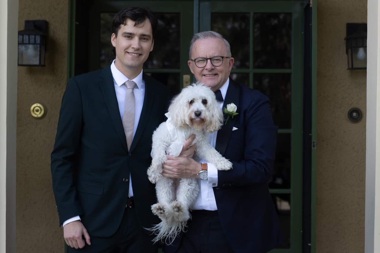 Prime Minister Anthony Albanese standing beside his son Nathan and holding his dog Toto