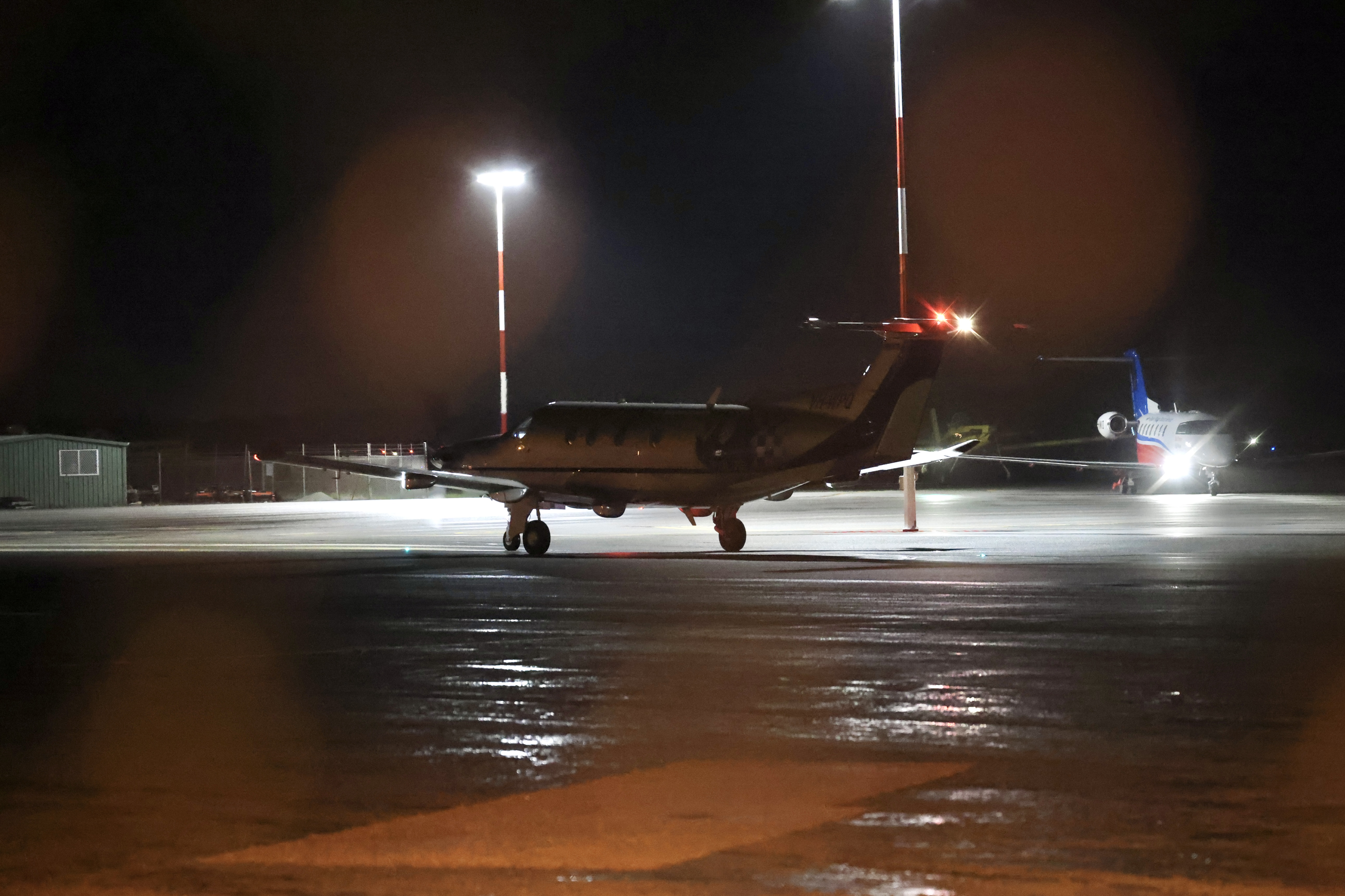 A dark shot of a small plane on a runway