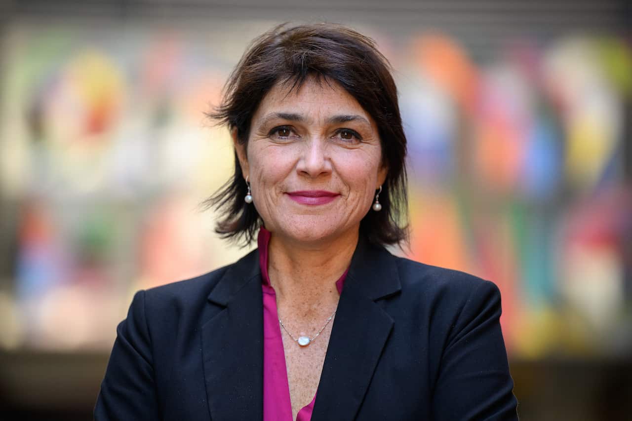 A woman in a black blazer and pink shirt