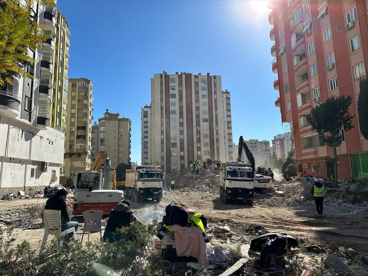 People search through the rubble of an apartment building