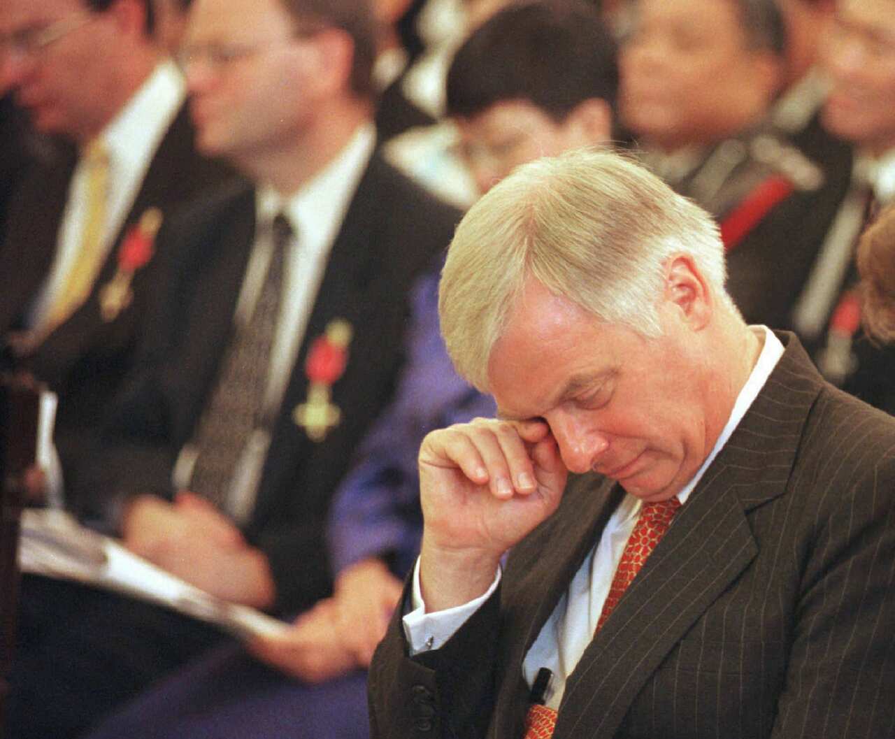 Former British governor Chris Patten wipes his eye