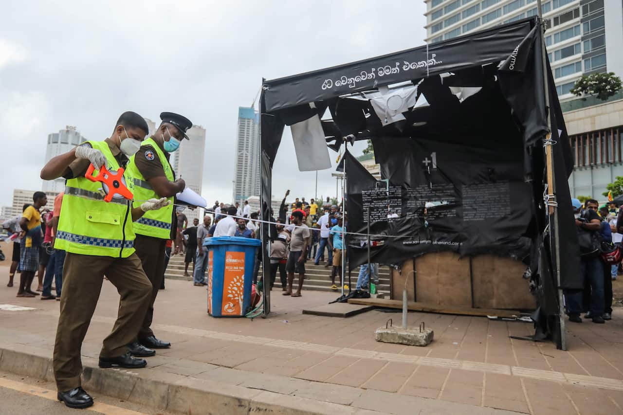 Police inspect the debris of the torched tents of anti-government protesters.