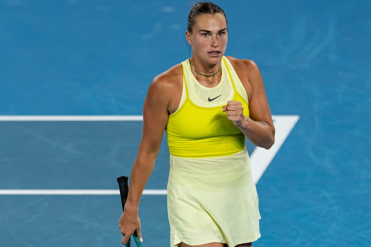A tennis player in a yellow uniform holding a racquet on a court.
