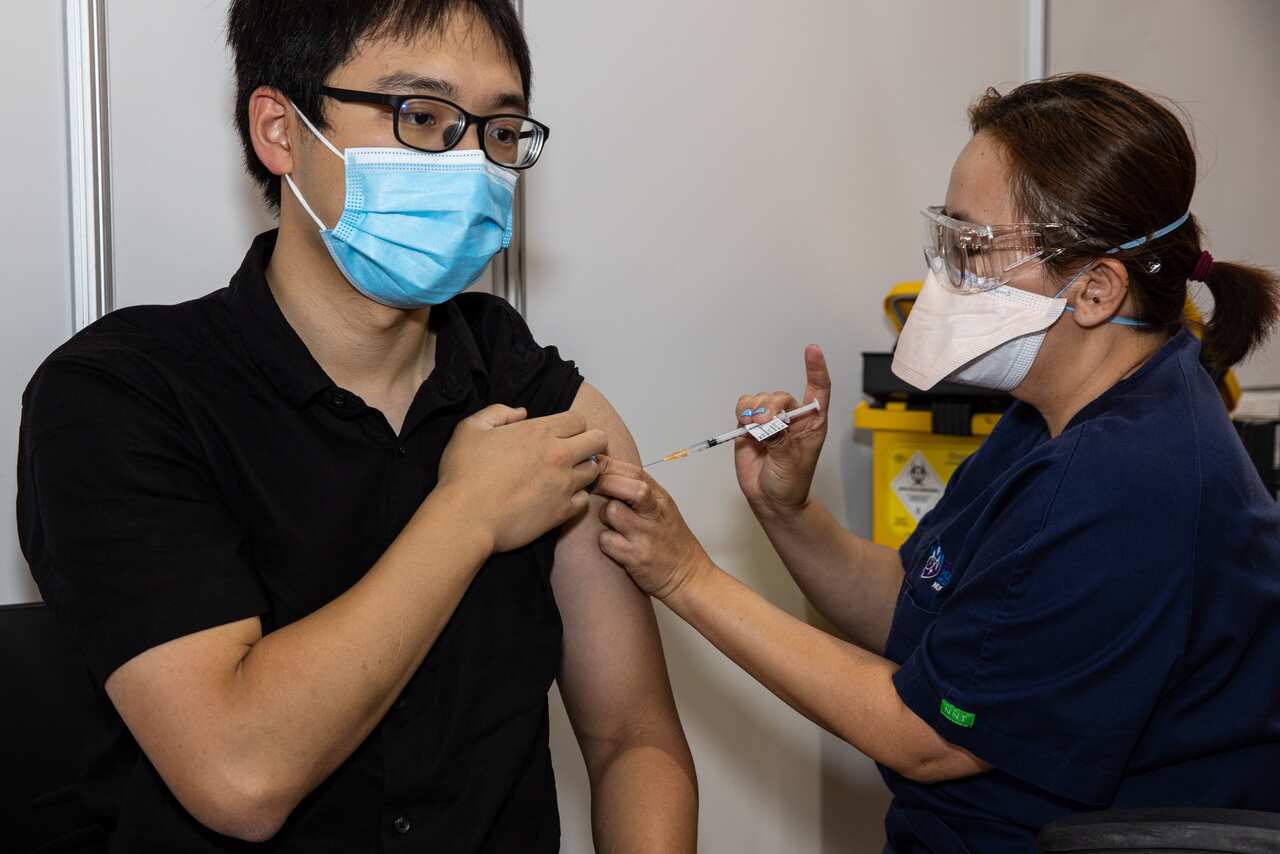 A woman gives a man an injection