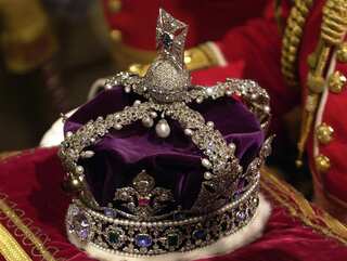 The Imperial State Crown sits on the red velvet home in Westminster, London.