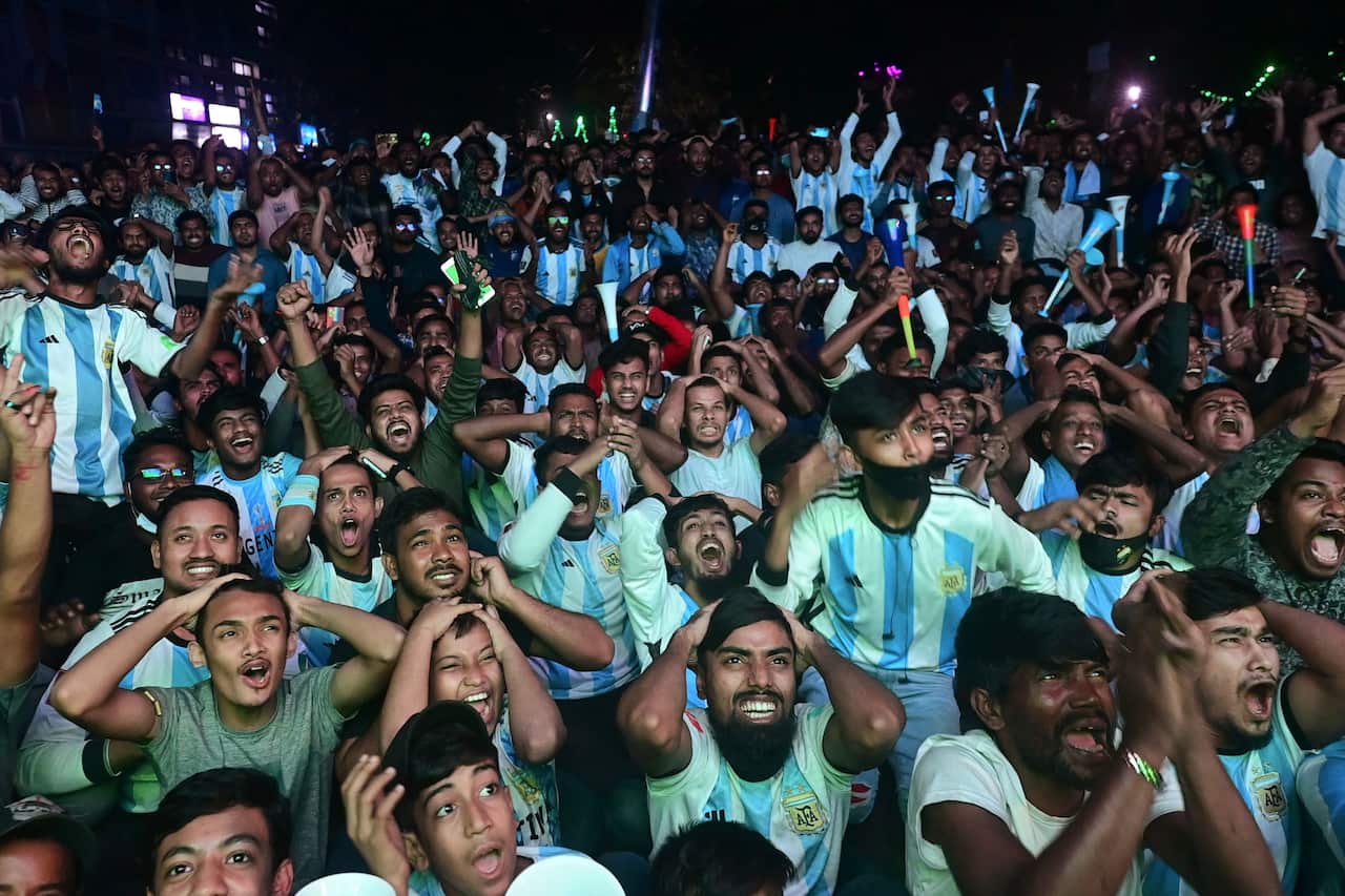 Men in blue and white jerseys look shocked, looking up.