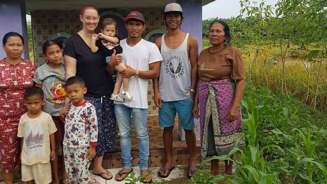 A group of men, women and children standing outside