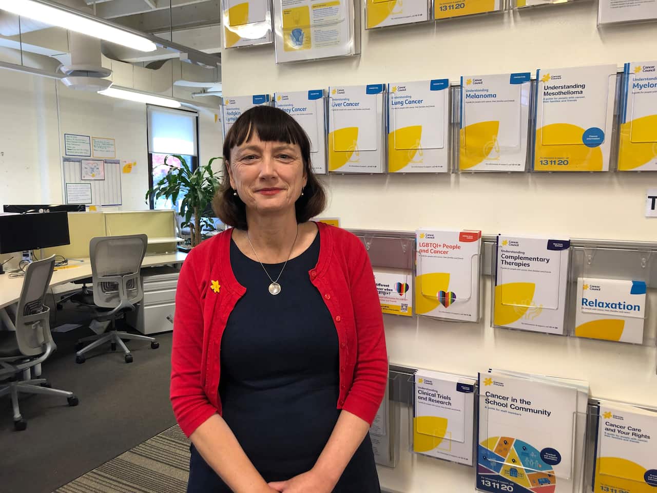 Jenni Bruce standing in front of Cancer Council information booklets