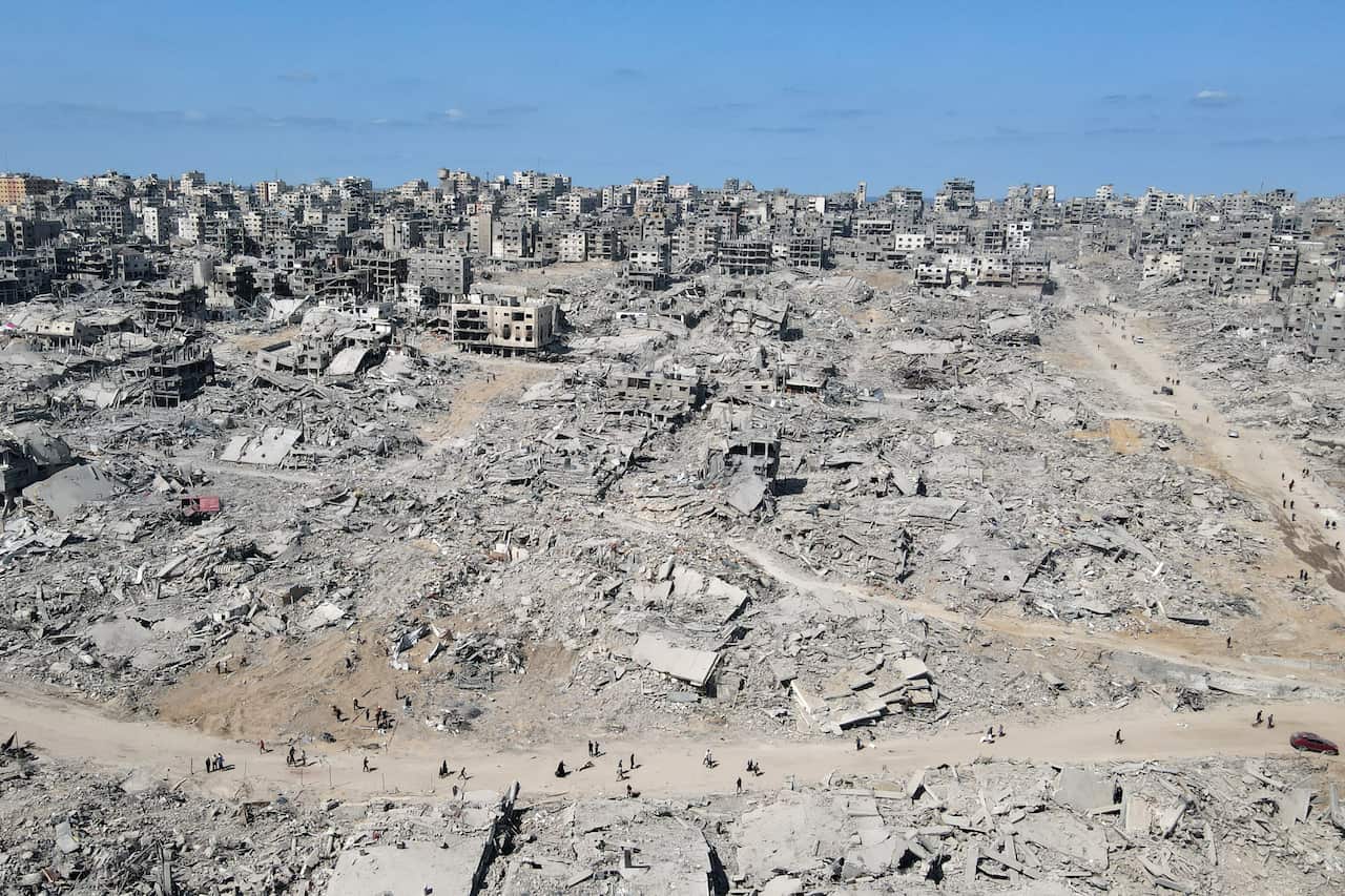 In this aerial view, People walk amid the destruction in Gaza City in the northern Gaza Strip