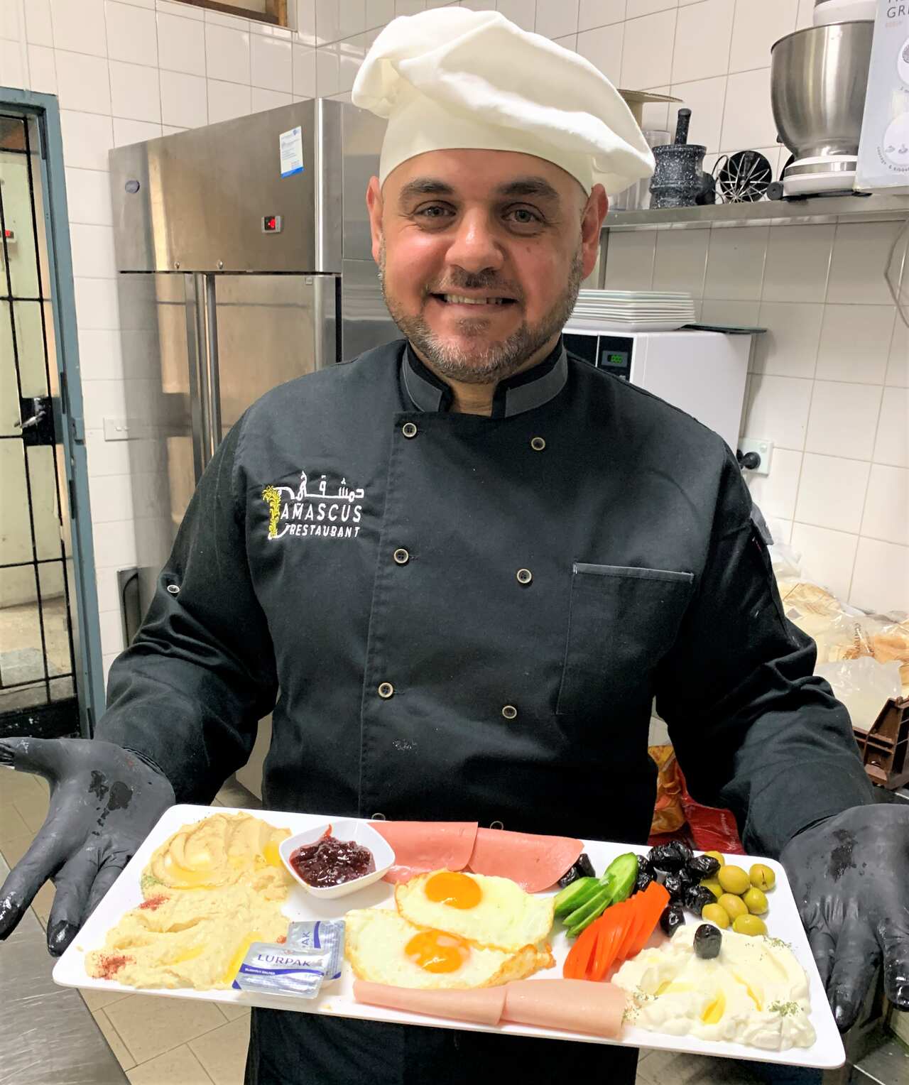 Talal Almardoud with a platter of Syrian food