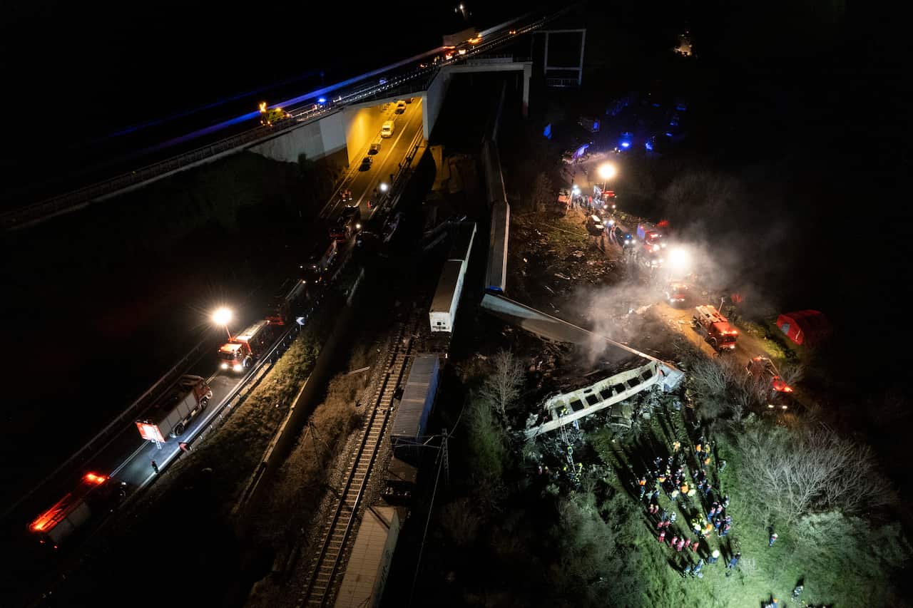 Rescue crews work at the site of a late-night train collision. 