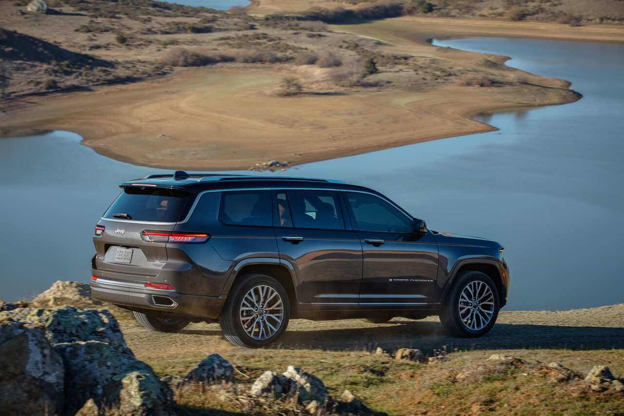 A promotional photo shows a Jeep SUV parked on the top of a grassy hill overlooking a lake