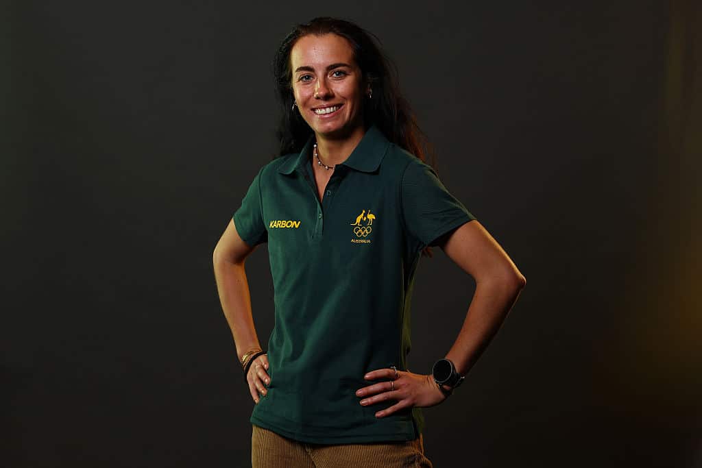 A woman wearing a green polo shirt with a yellow Australian coat of arms on the left breast