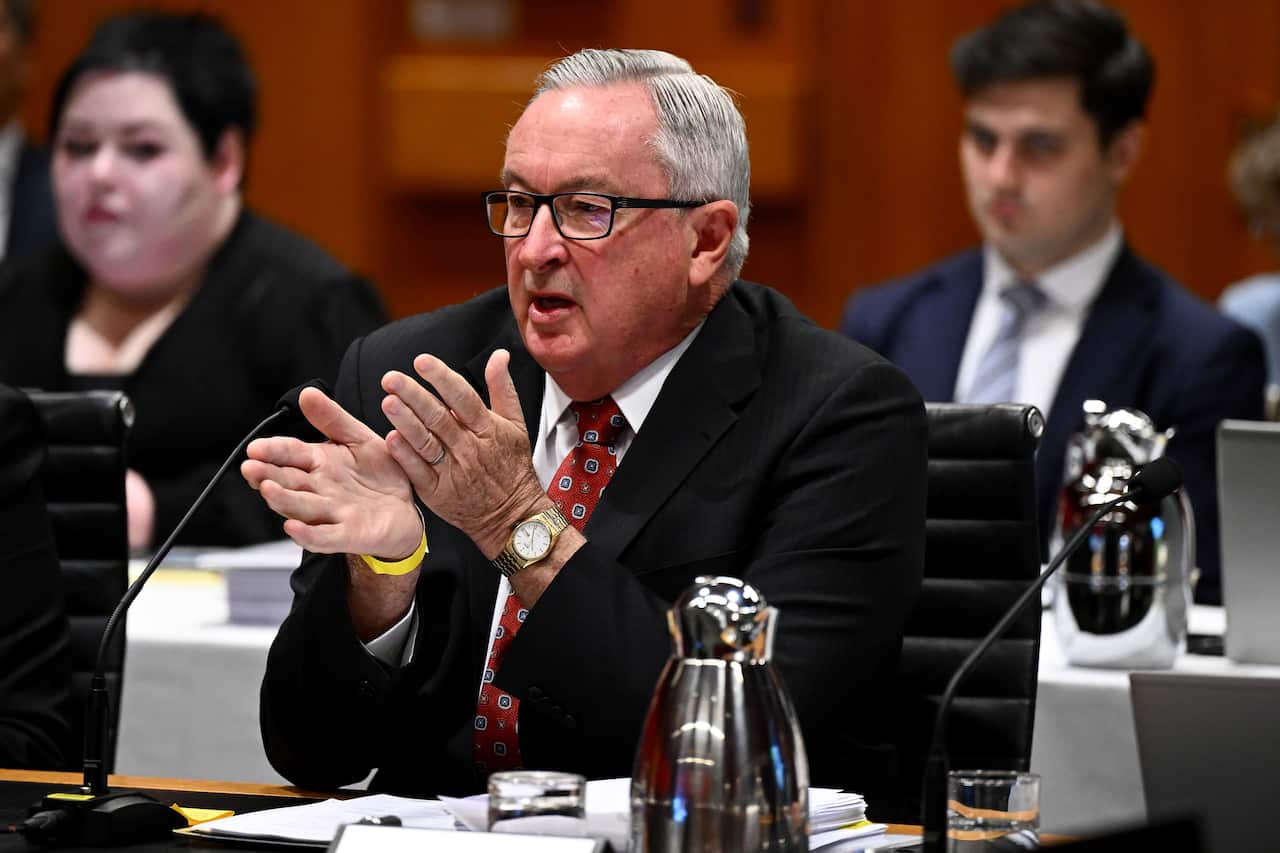 Brad Hazzard sitting at a desk and speaking