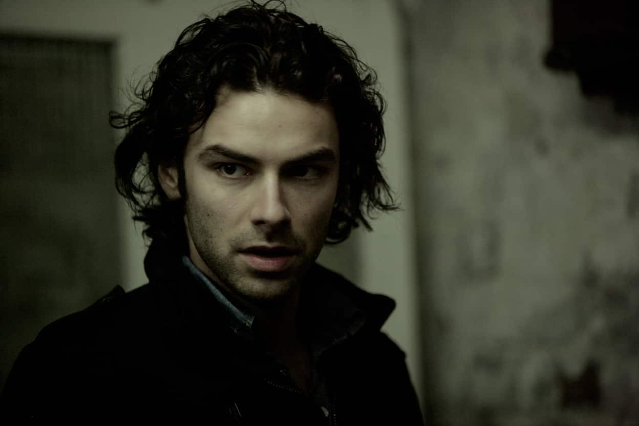 A young man stands in a house looking worried or on alert.jpg