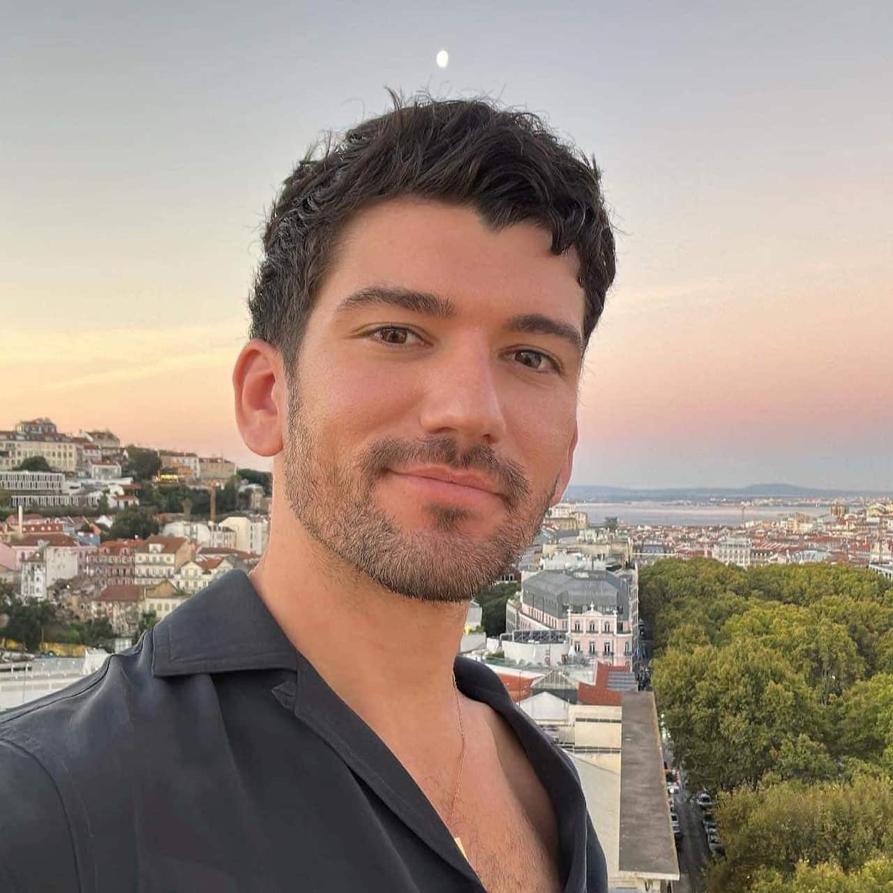 A man in a black shirt in front of a sunset