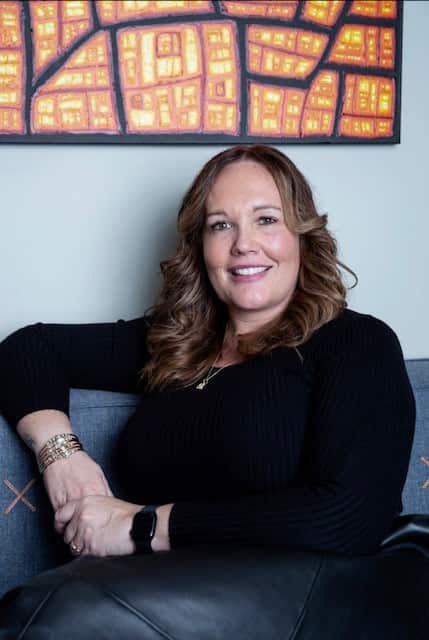 Woman sitting on lounge smiling at camera