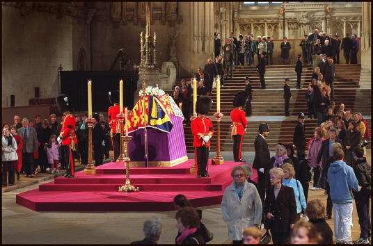 Mourners file past the coffin of the Queen Mother, which is placed on a platform and covered with a flag, at Westminster Hall in 2002.