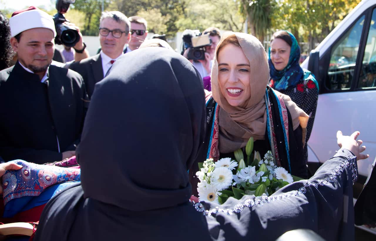Jacinda Ardern is embraced by a woman as she arrives at a mosque.