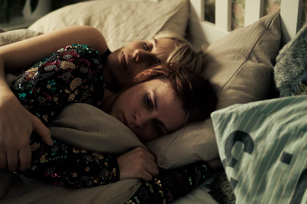 Two middle-aged women, sisters, lie in bed together in their pyjamas.jpeg