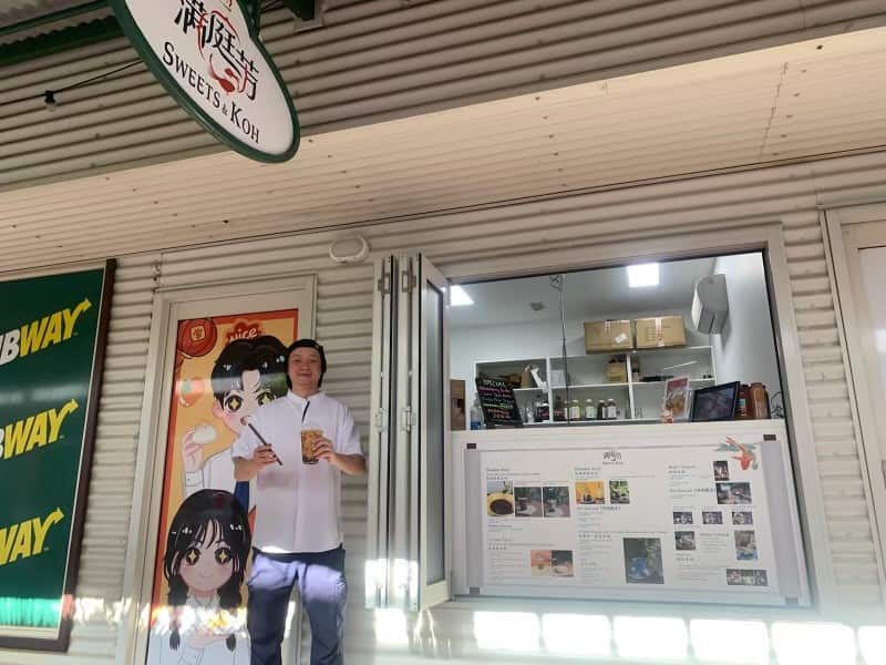 Man standing outside a bubble tea store.