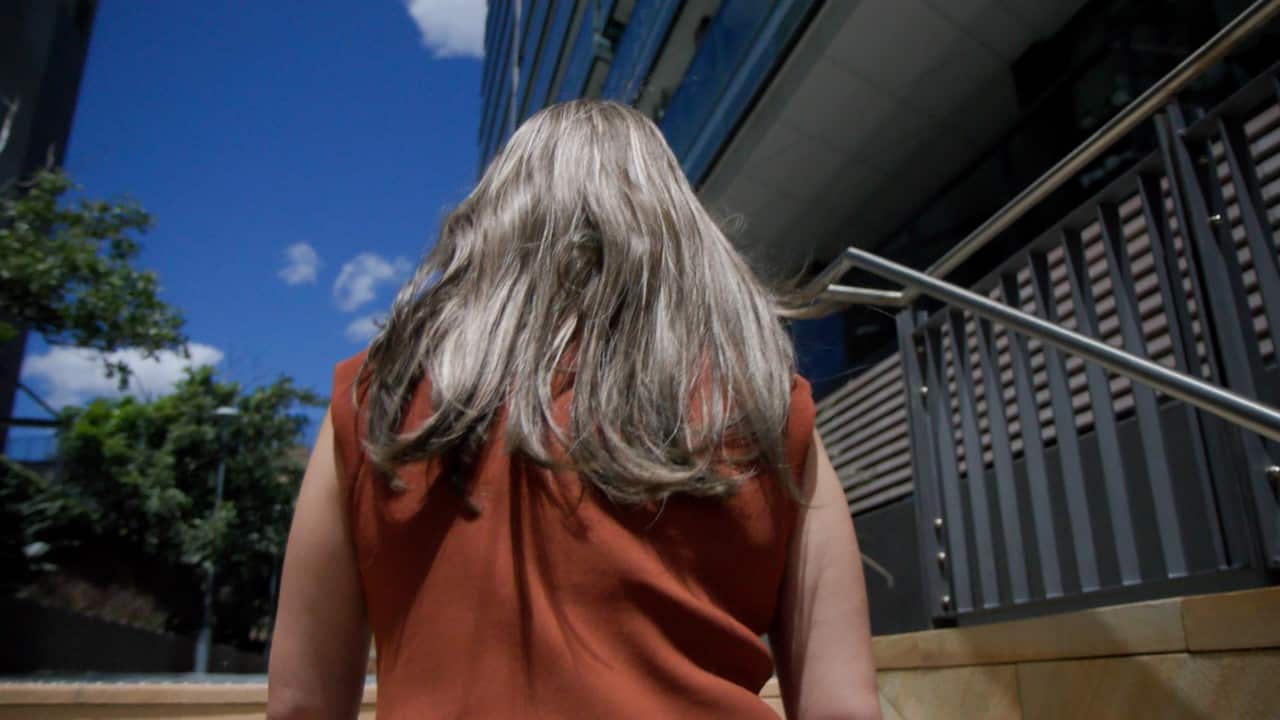 A close-up woman walking up a set of stairs. 